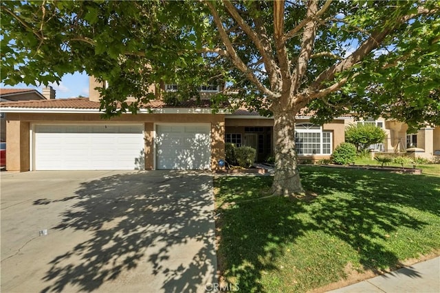 42012 57th St W, Lancaster, CA 93536 - obstructed view of property with concrete driveway, stucco siding, a front lawn, and a tile roof