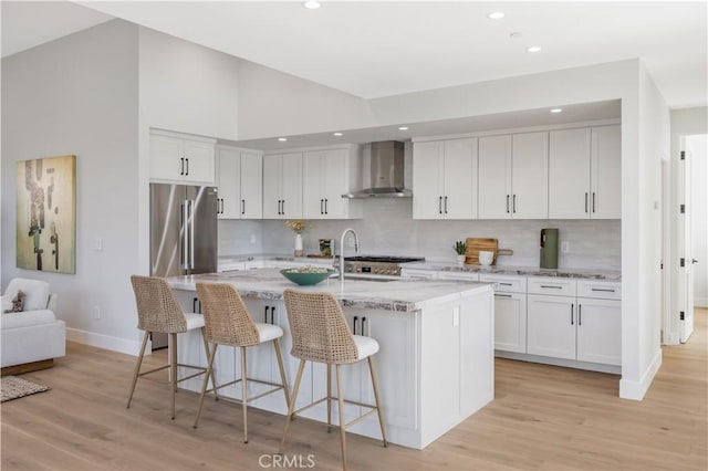 2405 Mathews Ave Unit C, Redondo Beach, CA 90278 - kitchen featuring wall chimney exhaust hood, light wood-style floors, high quality fridge, backsplash, and recessed lighting