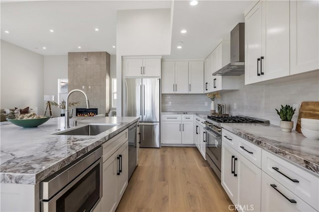 2405 Mathews Ave Unit C, Redondo Beach, CA 90278 - kitchen featuring wall chimney range hood, stainless steel appliances, white cabinetry, light wood finished floors, and recessed lighting