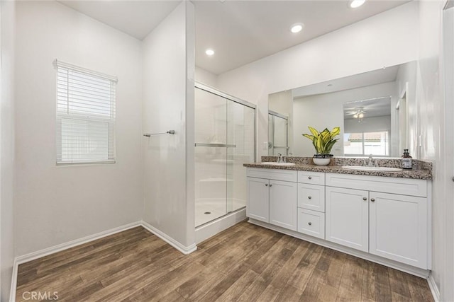 7305 Scrivia Ct, Bakersfield, CA 93311 - full bath with wood finished floors, a shower stall, double vanity, ceiling fan, and recessed lighting