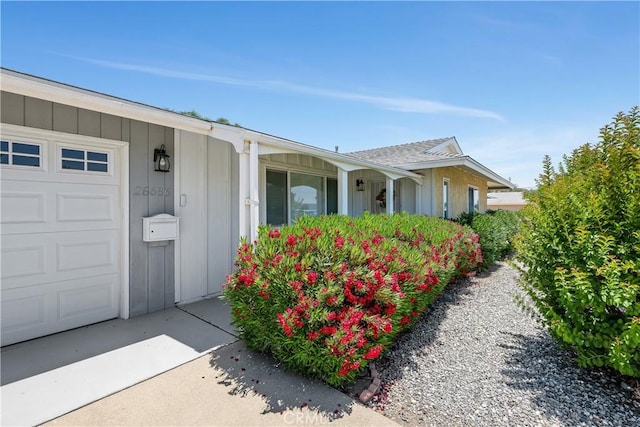 28656 Bradley Rd, Menifee, CA 92586 - view of front facade featuring covered porch, a garage, and board and batten siding
