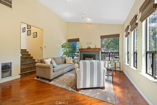 5375 Rosario Ave, Atascadero, CA 93422 - living room featuring wood finished floors, a fireplace, stairway, and high vaulted ceiling