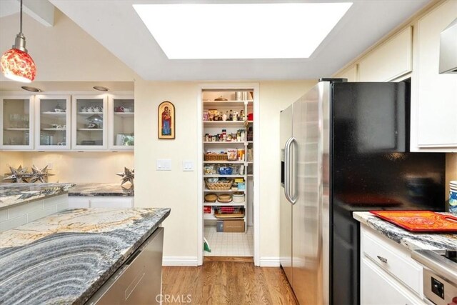 5375 Rosario Ave, Atascadero, CA 93422 - kitchen with light wood finished floors, stainless steel fridge with ice dispenser, light stone countertops, glass insert cabinets, and pendant lighting