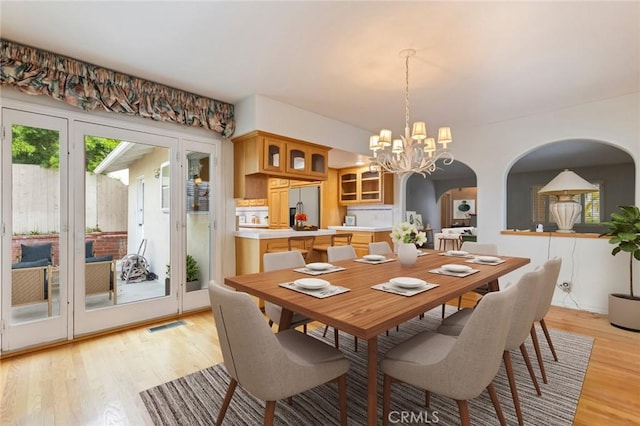 1716 Elm Ave, Manhattan Beach, CA 90266 - dining area featuring a chandelier, light wood-type flooring, and arched walkways