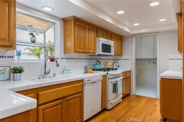 1716 Elm Ave, Manhattan Beach, CA 90266 - kitchen featuring white appliances, light wood-type flooring, backsplash, brown cabinets, and recessed lighting