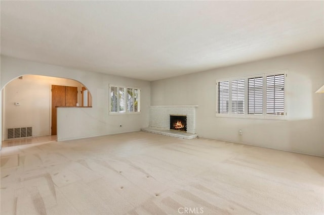 1716 Elm Ave, Manhattan Beach, CA 90266 - unfurnished living room featuring arched walkways, carpet flooring, and a brick fireplace