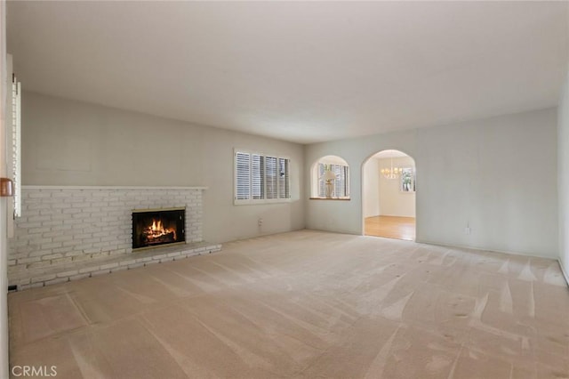 1716 Elm Ave, Manhattan Beach, CA 90266 - unfurnished living room featuring carpet floors, a brick fireplace, and arched walkways