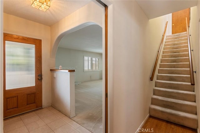 1716 Elm Ave, Manhattan Beach, CA 90266 - entrance foyer with arched walkways, stairway, light tile patterned floors, and light carpet