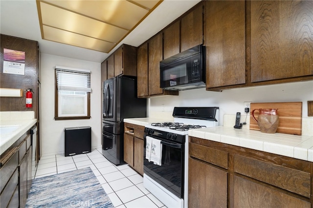 1722 Tiffany Ct, Ontario, CA 91762 - kitchen featuring black appliances, light tile patterned floors, dark brown cabinets, and tile countertops