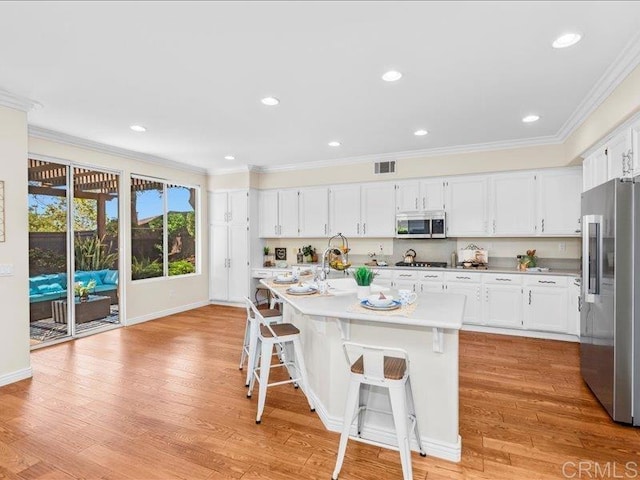 2381 Avenida Helecho, Carlsbad, CA 92009 - kitchen with stainless steel appliances, ornamental molding, white cabinetry, light wood-type flooring, and light countertops