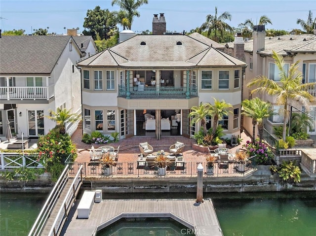 648 Harbor Island Dr, Newport Beach, CA 92660 - back of property with a balcony, stucco siding, a water view, and a chimney