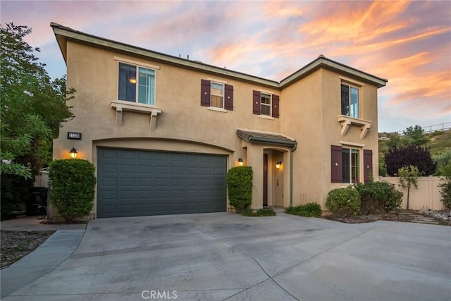 17138 Hickory Ridge Ct, Canyon Country, CA 91387 - view of front facade with stucco siding, an attached garage, and driveway