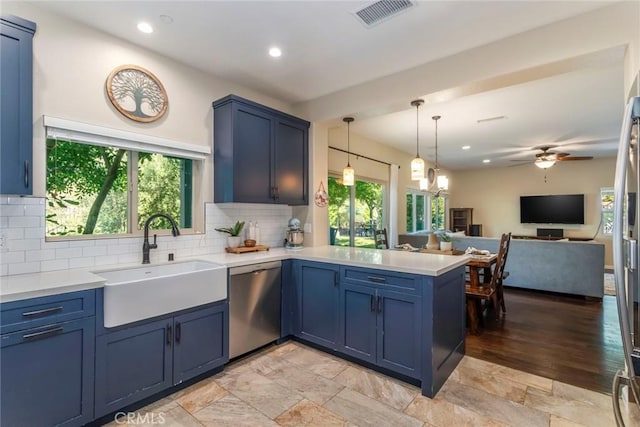 17138 Hickory Ridge Ct, Canyon Country, CA 91387 - kitchen with stainless steel dishwasher, a peninsula, blue cabinetry, light countertops, and tasteful backsplash
