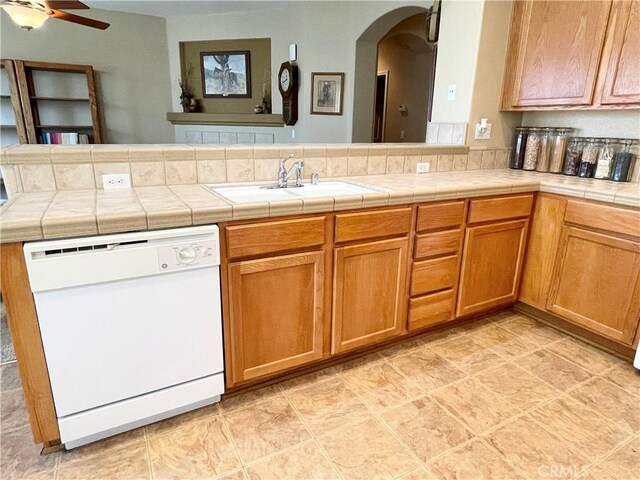 3803 Colma Ct, Merced, CA 95348 - kitchen with white dishwasher, a ceiling fan, arched walkways, and brown cabinets