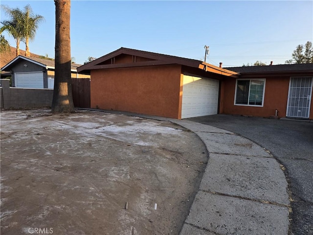 3608 Wagoner Ln, Corona, CA 92879 - view of side of property with stucco siding, an attached garage, and asphalt driveway