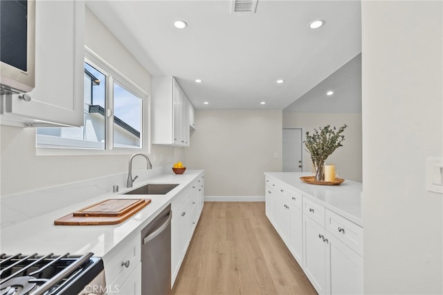 12847 Winthrop Ave, Granada Hills, CA 91344 - kitchen with appliances with stainless steel finishes, light wood-style flooring, recessed lighting, white cabinets, and light countertops