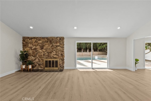 12847 Winthrop Ave, Granada Hills, CA 91344 - unfurnished living room featuring wood finished floors, a stone fireplace, plenty of natural light, recessed lighting, and lofted ceiling