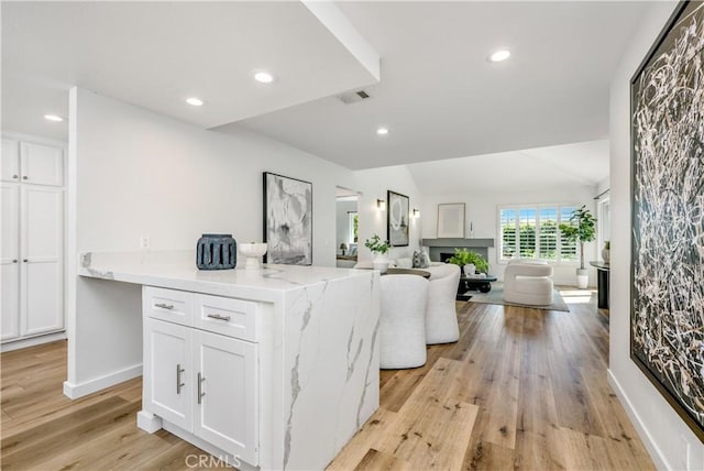 503 Morning Canyon Rd Unit 9, Corona Del Mar, CA 92625 - kitchen featuring white cabinetry, recessed lighting, open floor plan, light wood-style flooring, and light stone countertops