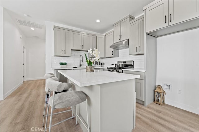 13154 Cedar St, Westminster, CA 92683 - kitchen featuring stainless steel range, under cabinet range hood, gray cabinets, decorative backsplash, and recessed lighting