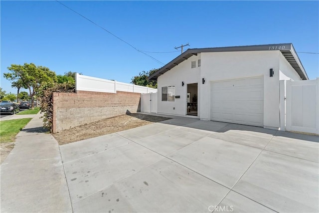 13154 Cedar St, Westminster, CA 92683 - view of side of home with stucco siding, concrete driveway, and a garage
