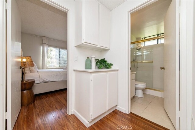 9 Morena Unit 28, Irvine, CA 92612 - full bathroom featuring a shower stall, ensuite bathroom, and wood finished floors