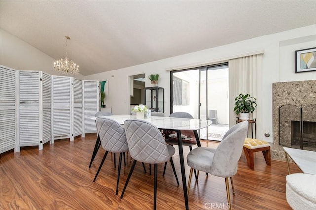9 Morena Unit 28, Irvine, CA 92612 - dining room featuring a chandelier, dark wood-style flooring, lofted ceiling, and a fireplace with raised hearth