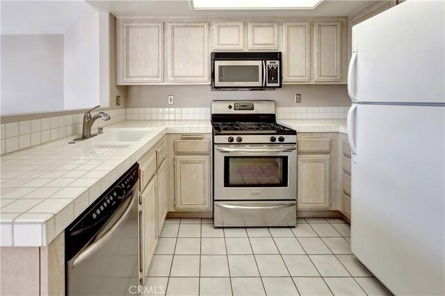 27982 Via Del Agua, Laguna Niguel, CA 92677 - kitchen with appliances with stainless steel finishes, tile countertops, light tile patterned flooring, and cream cabinets