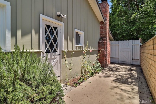 17654 Prairie St, Northridge, CA 91325 - view of property exterior with a gate, board and batten siding, and a chimney