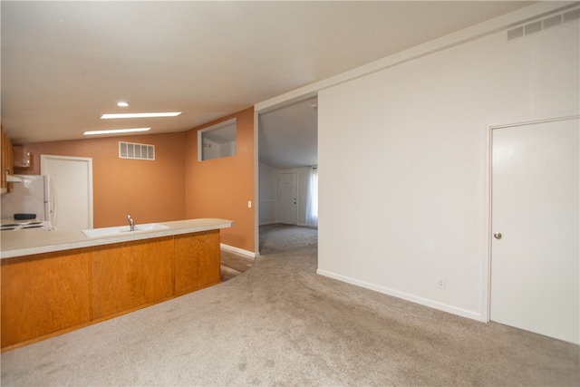 3556 Cypress St, Clearlake, CA 95422 - kitchen featuring vaulted ceiling, light colored carpet, freestanding refrigerator, a peninsula, and light countertops