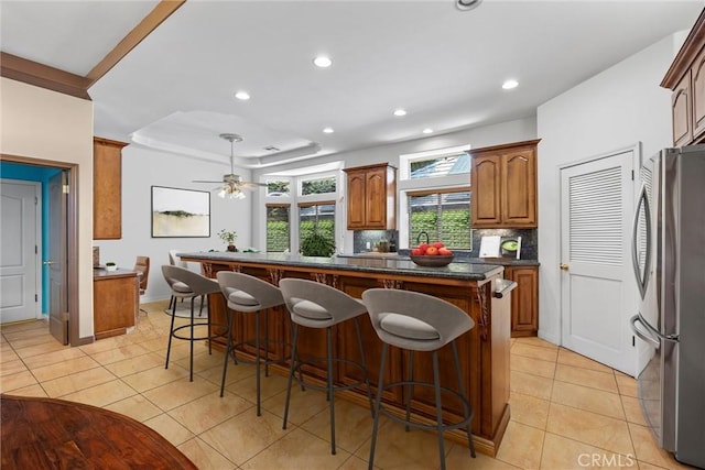 1806 Briercliff Ct, Bakersfield, CA 93311 - kitchen with freestanding refrigerator, light tile patterned floors, recessed lighting, and a breakfast bar