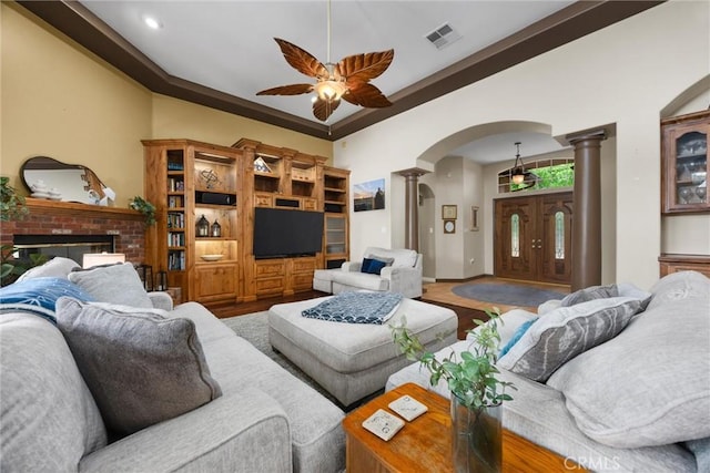 1806 Briercliff Ct, Bakersfield, CA 93311 - living room with decorative columns, arched walkways, a ceiling fan, wood finished floors, and a fireplace