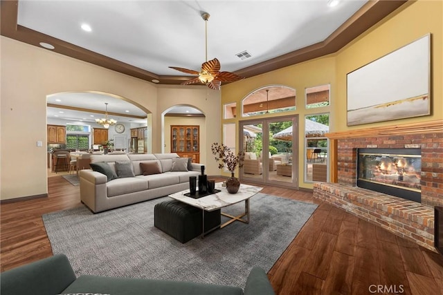 1806 Briercliff Ct, Bakersfield, CA 93311 - living room with arched walkways, a raised ceiling, recessed lighting, wood finished floors, and a fireplace