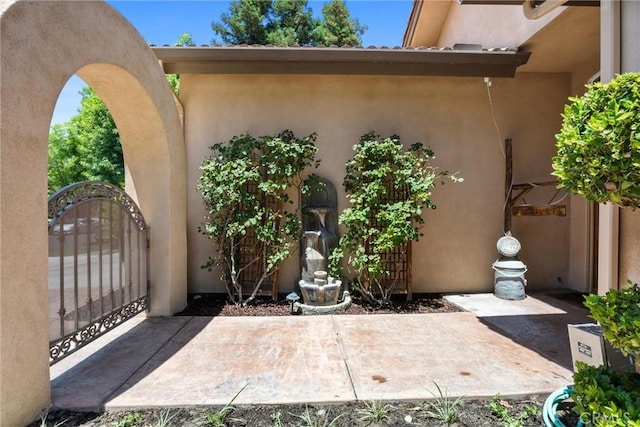 1806 Briercliff Ct, Bakersfield, CA 93311 - view of exterior entry with stucco siding, a patio area, and a gate