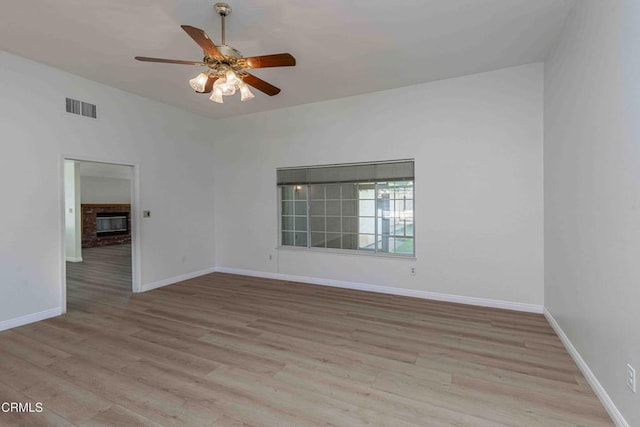 4120 Abbott Dr, Bakersfield, CA 93312 - spare room with light wood-style floors, a ceiling fan, and a brick fireplace
