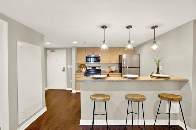 425 W Beech St Unit 417, San Diego, CA 92101 - kitchen with stainless steel appliances, a peninsula, a kitchen bar, dark wood-style floors, and recessed lighting