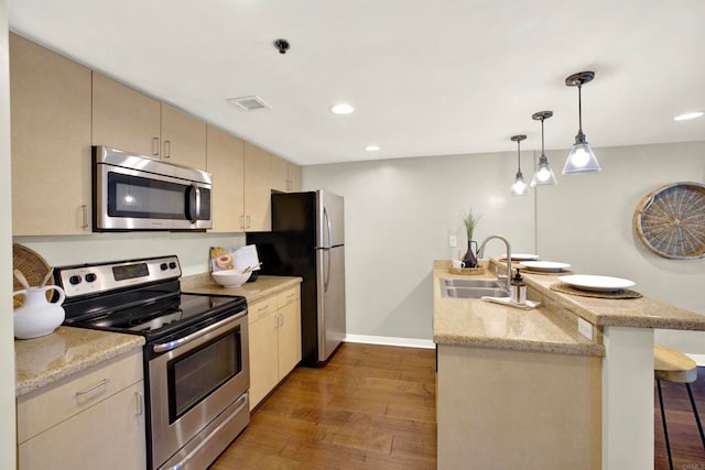 425 W Beech St Unit 417, San Diego, CA 92101 - kitchen with appliances with stainless steel finishes, a peninsula, dark wood finished floors, a breakfast bar area, and recessed lighting