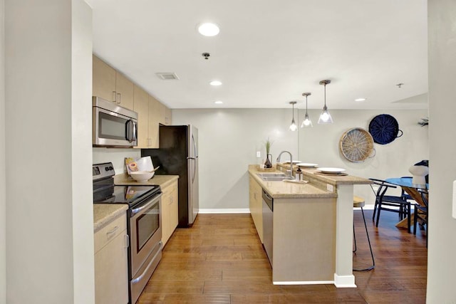 425 W Beech St Unit 417, San Diego, CA 92101 - kitchen with appliances with stainless steel finishes, a kitchen bar, a peninsula, wood-type flooring, and recessed lighting