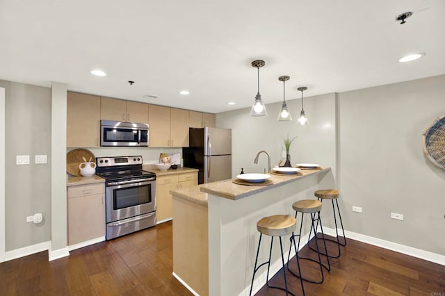 425 W Beech St Unit 417, San Diego, CA 92101 - kitchen featuring appliances with stainless steel finishes, a breakfast bar area, dark wood-type flooring, a peninsula, and recessed lighting