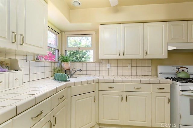 869 Phillips St, Vista, CA 92083 - kitchen featuring white range with gas cooktop, white cabinetry, and backsplash