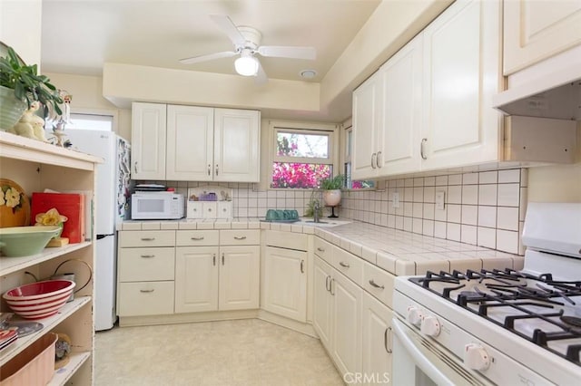 869 Phillips St, Vista, CA 92083 - kitchen featuring white appliances, tile countertops, white cabinetry, decorative backsplash, and a ceiling fan