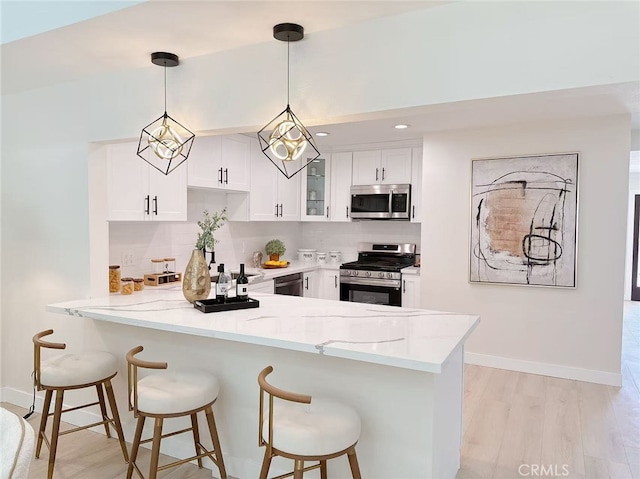 23615 Tellgate Dr, Diamond Bar, CA 91765 - kitchen featuring stainless steel appliances, a peninsula, light stone counters, and glass insert cabinets