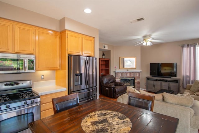 2414 Falcon Valley Dr, Chula Vista, CA 91914 - kitchen with appliances with stainless steel finishes, open floor plan, a ceiling fan, light countertops, and a brick fireplace