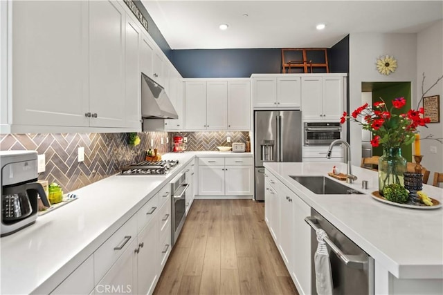 26957 Winding Trail Ct, Valencia, CA 91381 - kitchen featuring appliances with stainless steel finishes, under cabinet range hood, light countertops, white cabinets, and decorative backsplash