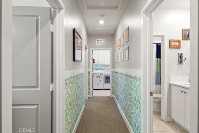 26957 Winding Trail Ct, Valencia, CA 91381 - hallway featuring washing machine and dryer, a wainscoted wall, and light tile patterned flooring