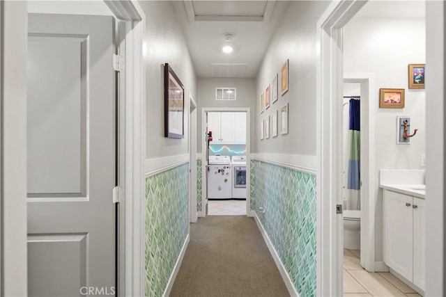 26957 Winding Trail Ct, Valencia, CA 91381 - hallway with washer and dryer, a wainscoted wall, and light tile patterned floors