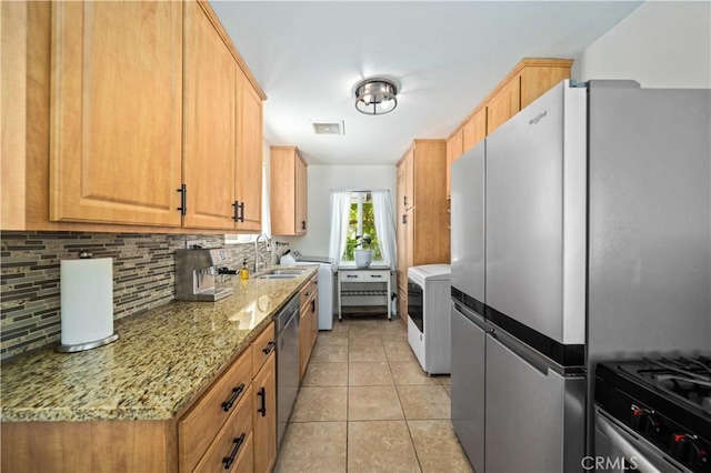 44055 Elm Ave, Lancaster, CA 93534 - kitchen featuring stainless steel appliances, washer / clothes dryer, backsplash, light tile patterned flooring, and light stone counters