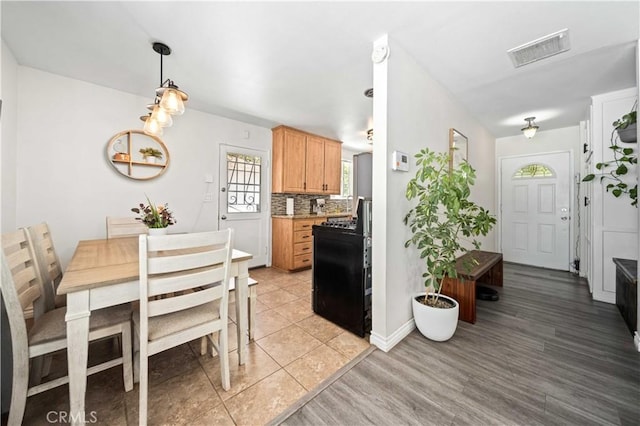 44055 Elm Ave, Lancaster, CA 93534 - kitchen with decorative backsplash, light wood finished floors, light countertops, and decorative light fixtures