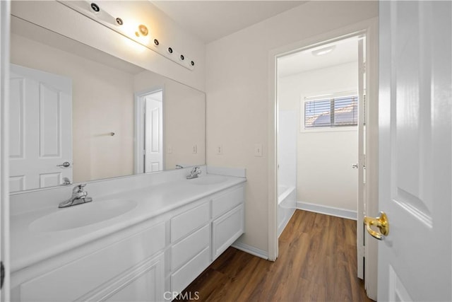 40225 Watford Way, Palmdale, CA 93551 - bathroom featuring double vanity, wood finished floors, and a bathtub