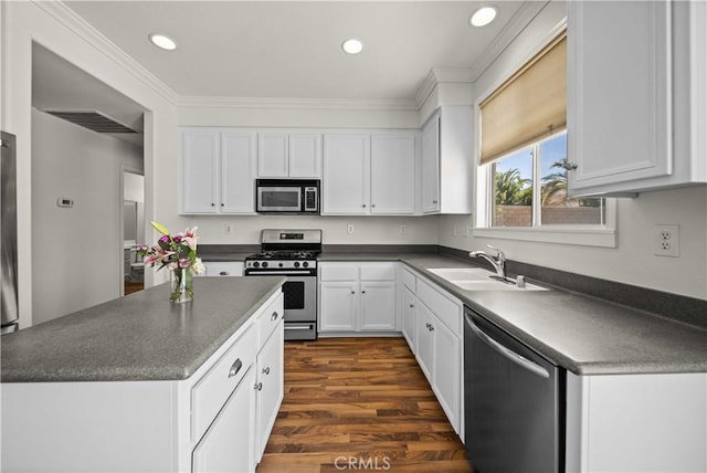 40225 Watford Way, Palmdale, CA 93551 - kitchen with stainless steel appliances, dark countertops, white cabinets, recessed lighting, and ornamental molding