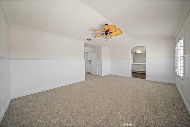 40225 Watford Way, Palmdale, CA 93551 - spare room with carpet floors, ceiling fan, a wainscoted wall, ornamental molding, and arched walkways
